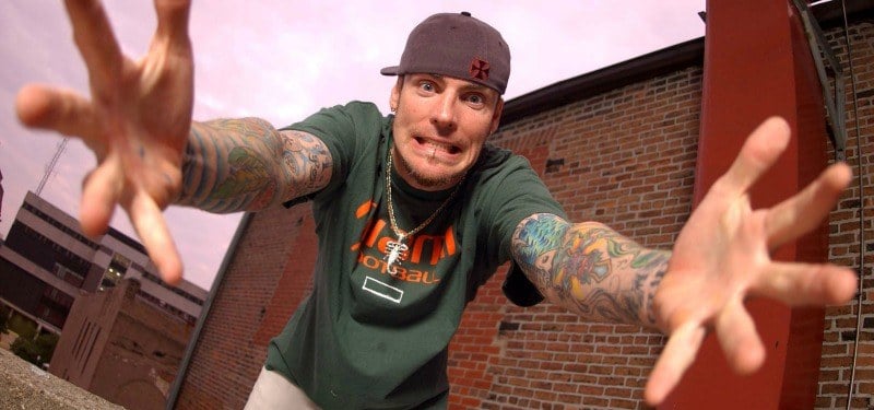 Vanilla Ice has his arms stretched out towards the camera.