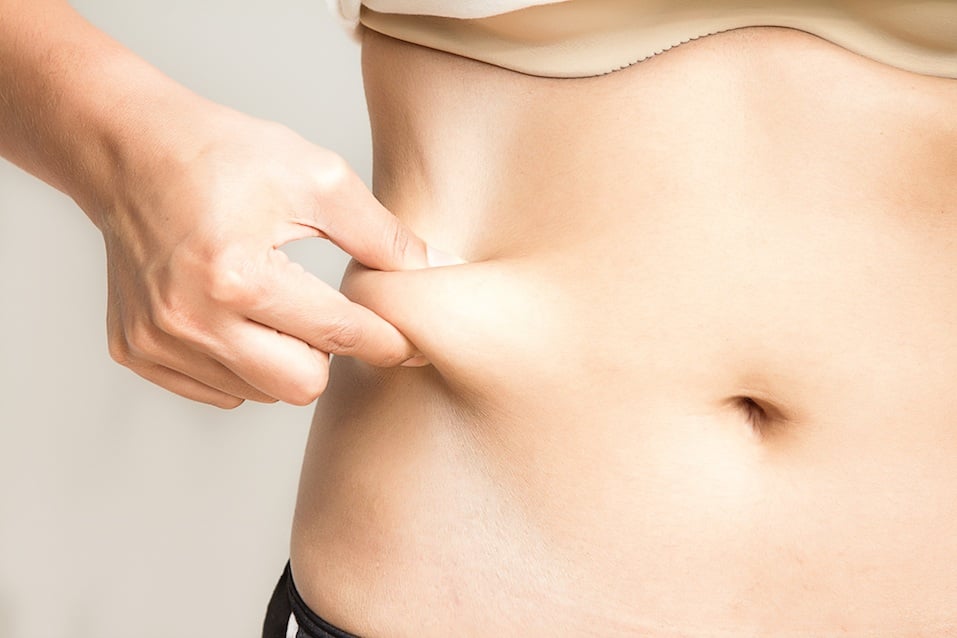 Woman measuring her belly fat with her hands