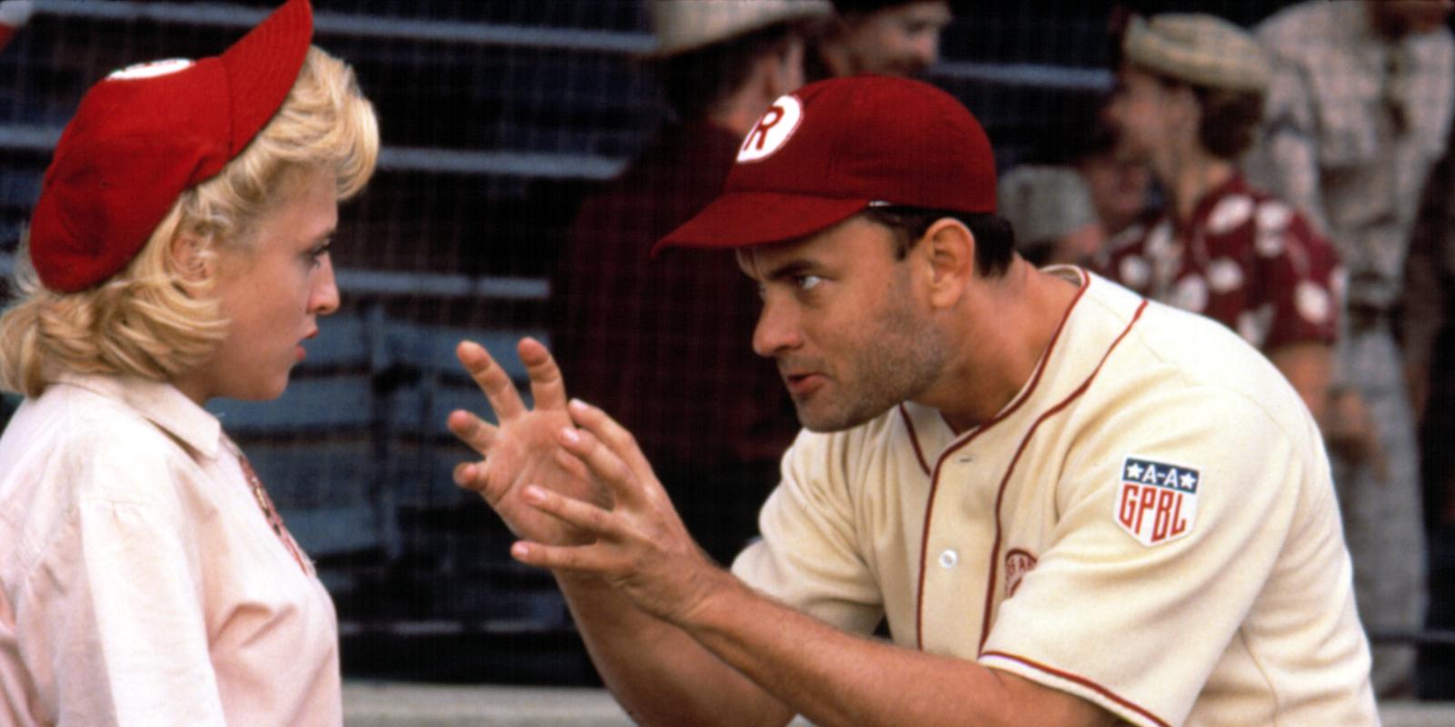 Tom Hanks in a baseball uniform, hunched over with his hands extended out toward Madonna, also in a baseball uniform