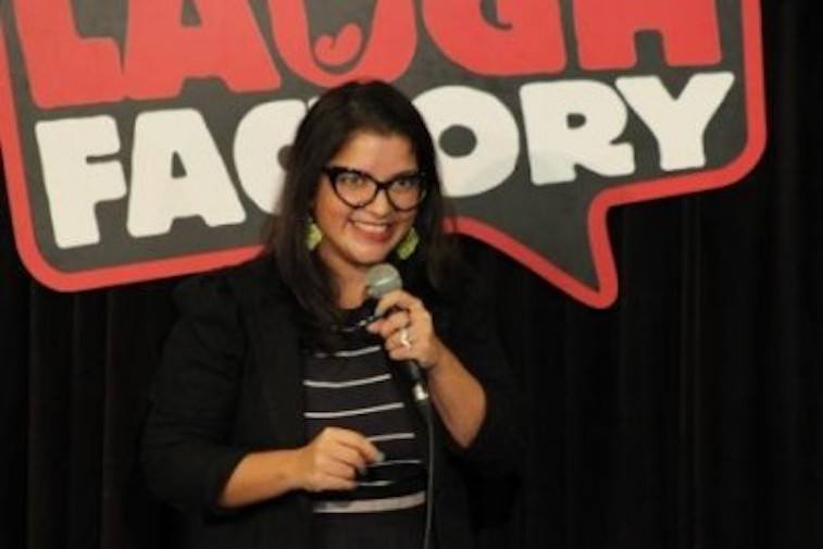 Aditi Mittal holds a microphone while performing on stage