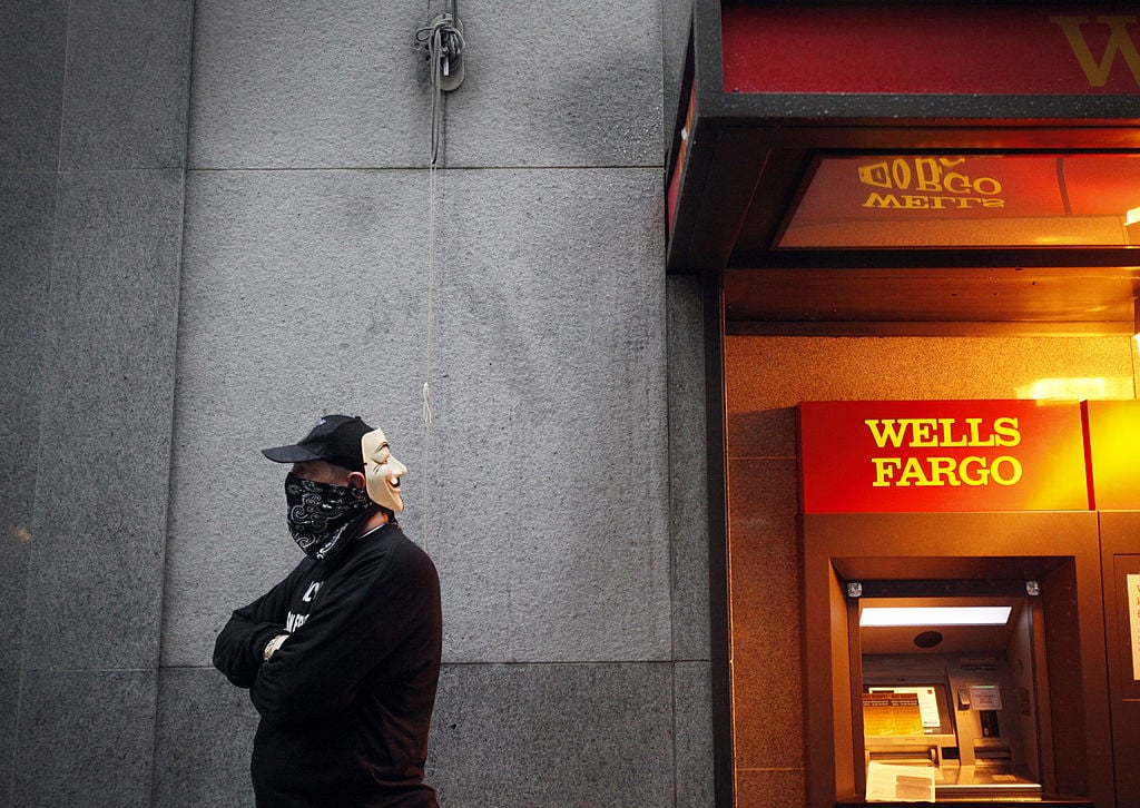 An "Occupy Wall Street West" protester next to Wells Fargo ATM