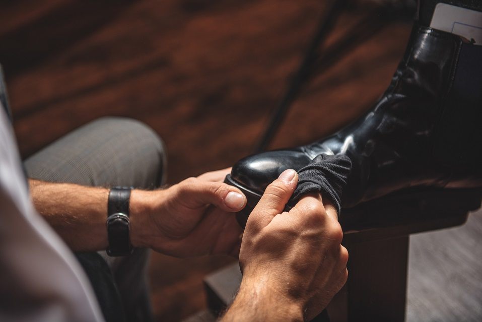 man cleaning dirt from footwear
