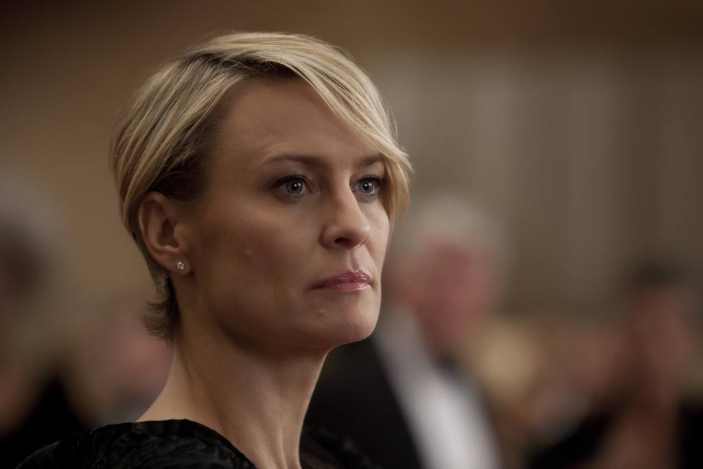 Claire Underwood in a black top, looking off to the right of the frame