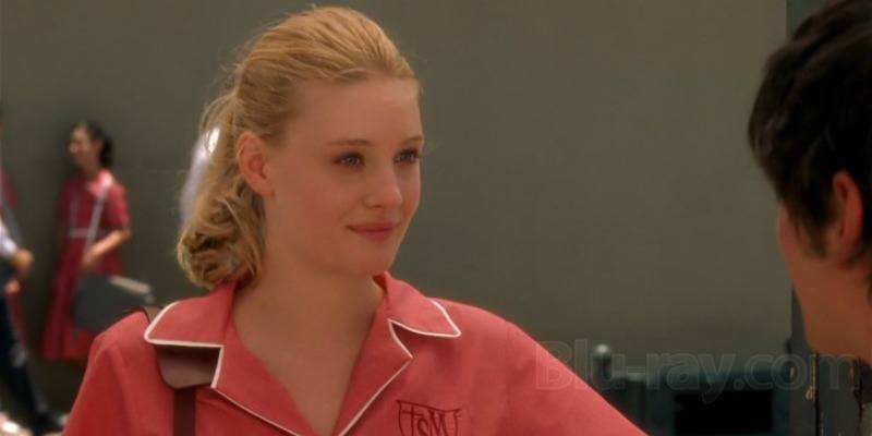 Romola Garai is smiling and wearing a pink shirt in Dirty Dancing Havana Nights.