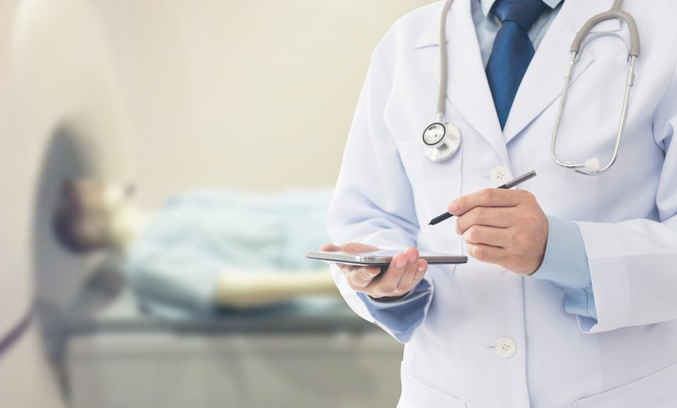 Doctor using a mobile phone notes scan brain results