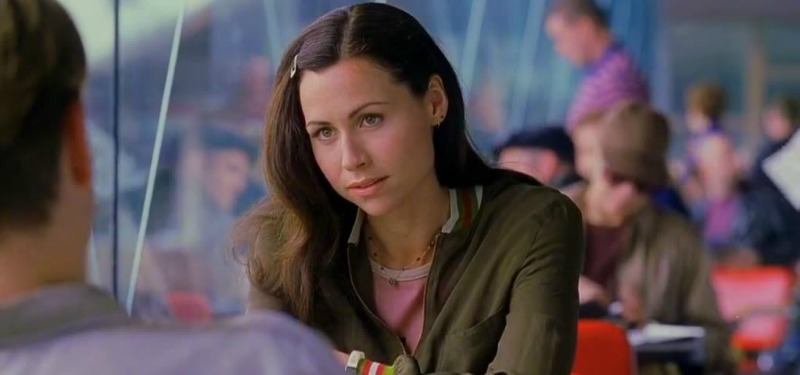 Minnie Driver is sitting at a table looking at Minnie Driver.