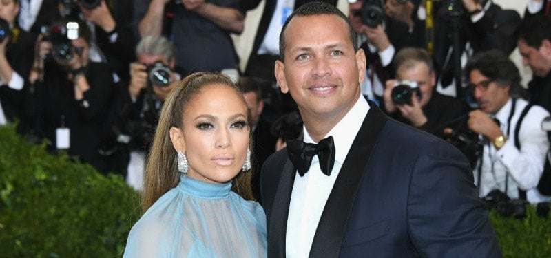 Jennifer Lopez is wearing a blue dress next to Alex Rodriguez who is in a tux.