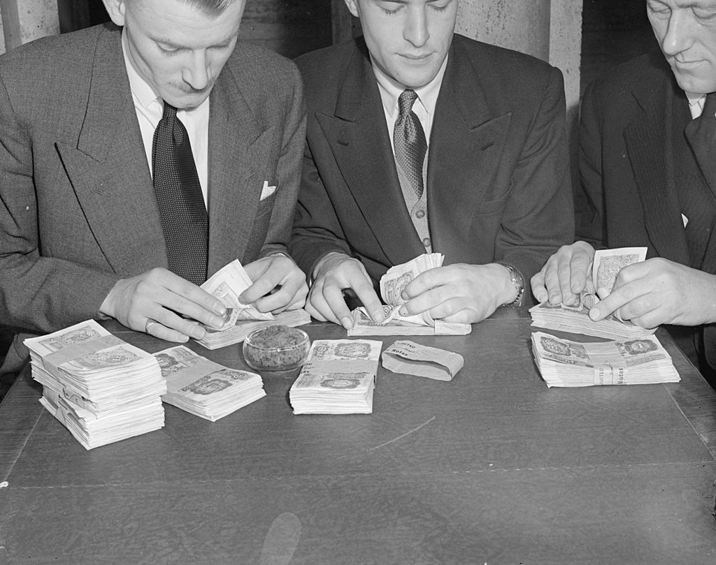 Men counting cash and discussing the concept of financial security
