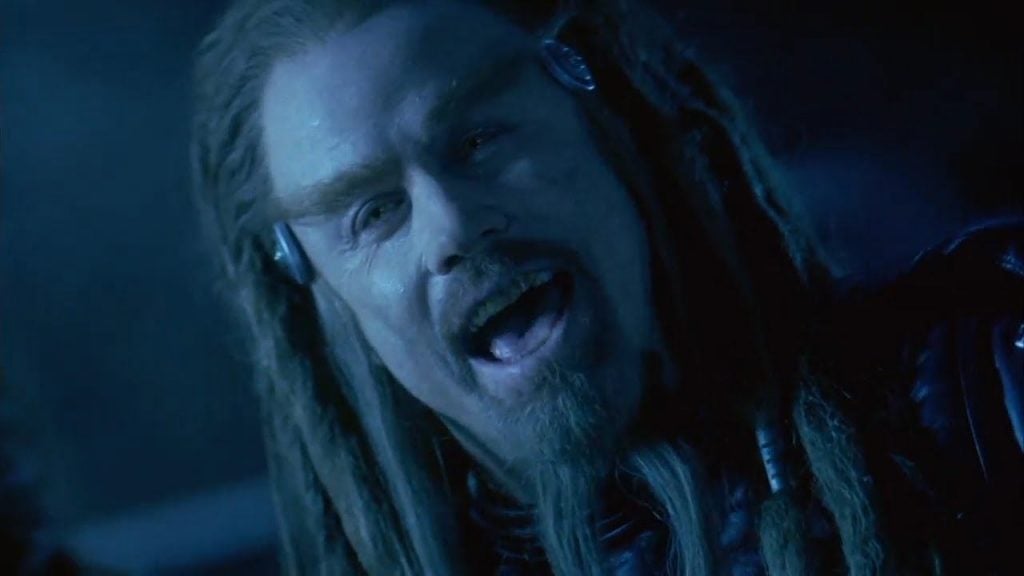 John Travolta as Terl, with long dreadlocks and a goatee, laughing into the camera