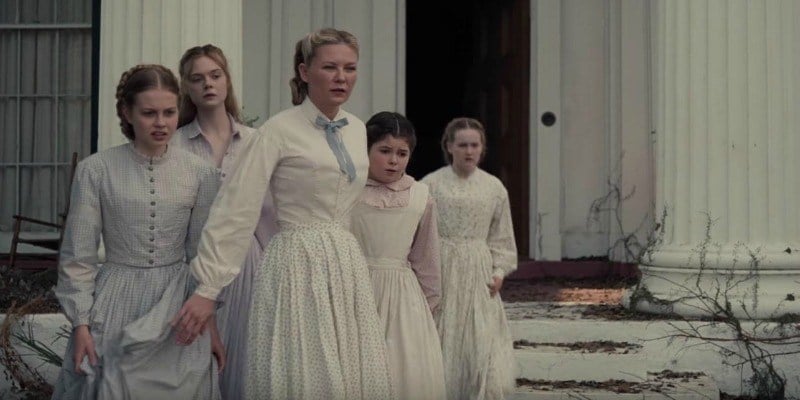 The female cast of The Beguiled stand outside of a house in white dresses. 