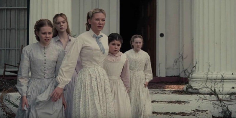 The female cast of The Beguiled stand outside of a house in white dresses.