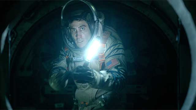 Jake Gyllenhaal holds up a flashlight in Life