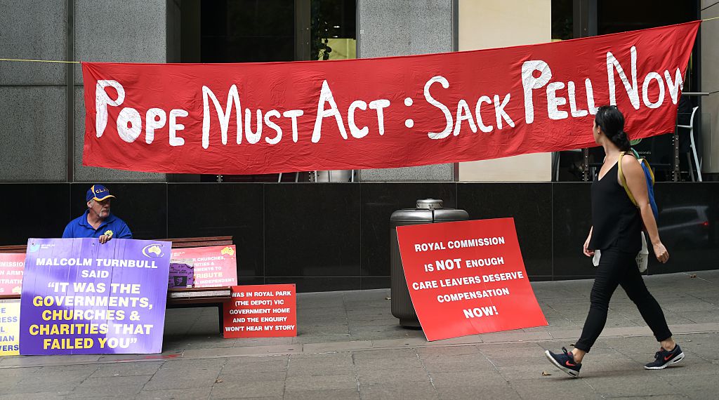 sign that says "pope must act: sack pell now"