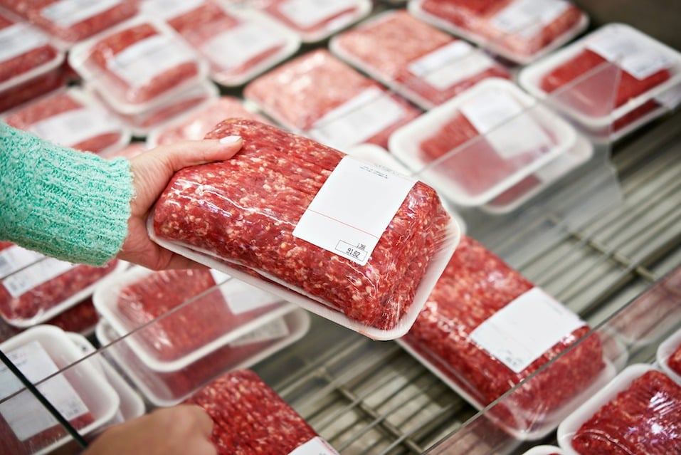 Buyer woman chooses chopped meat in a shop