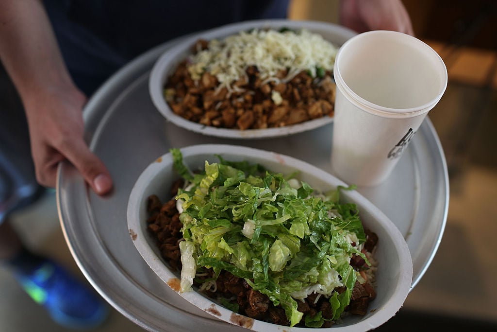 A customer carries a tray with his Chipotle food order