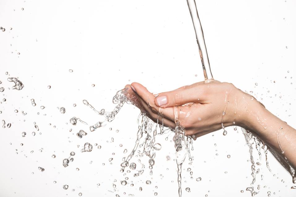 female hands under running water splash