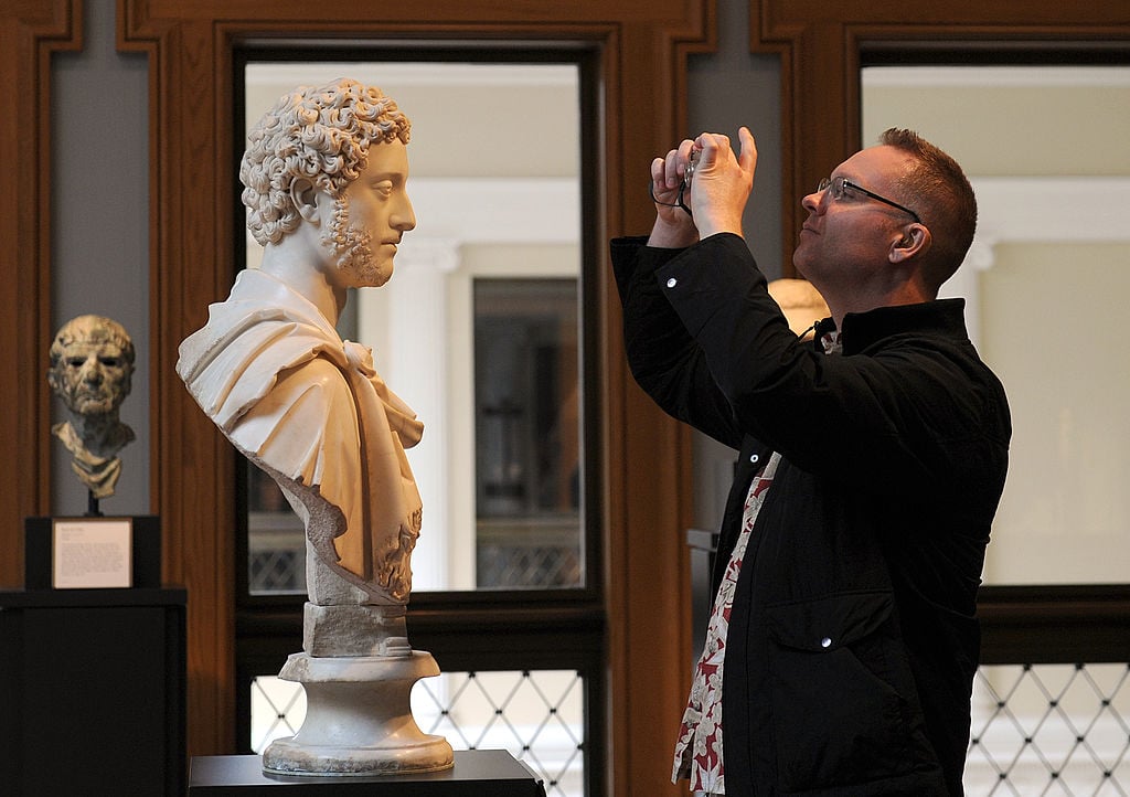 A visitor takes a picture of a bust of Roman Emperor Commodus.