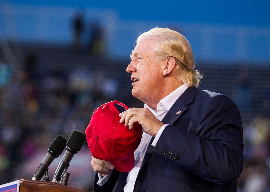 Donald Trump removes his hat to show his hair