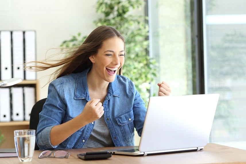 excited woman working on laptop