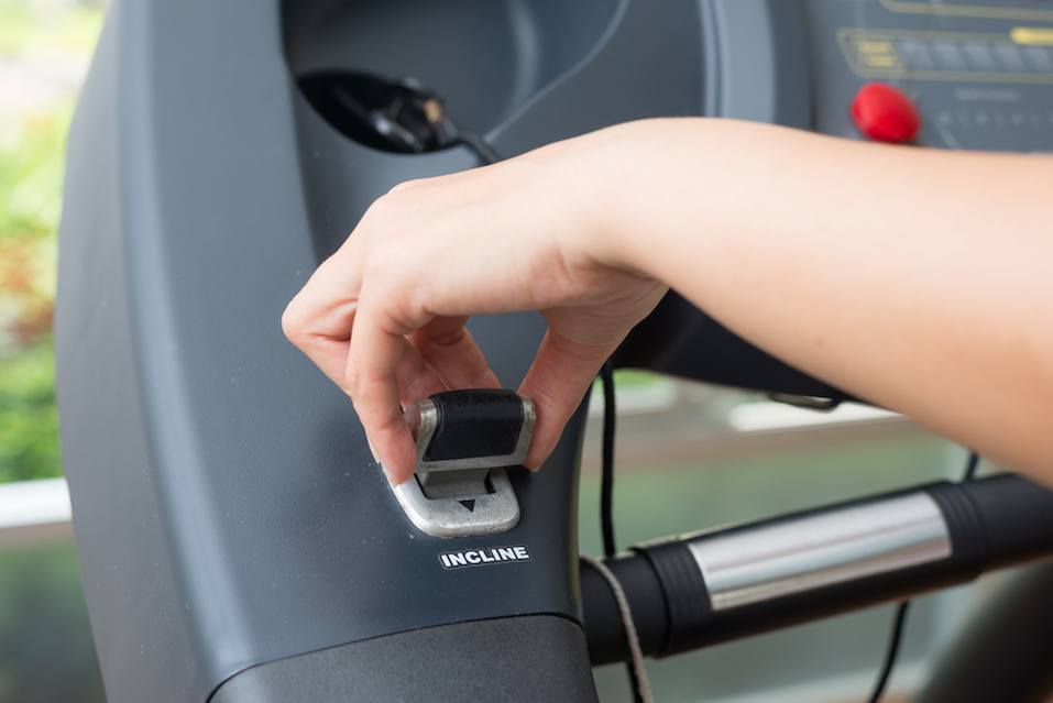 woman's hand adjustin incline stick on treadmill