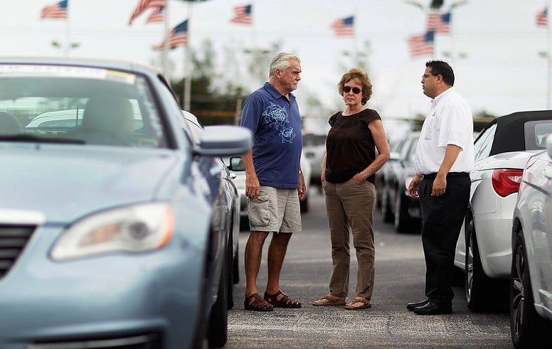 HOLLYWOOD, FL - OCTOBER 27: Salesman, JC Soto, (R) talks with customers, Paul Mulcahy and Sarah Even as they shop for a car on the sales lot of the Hollywood Chrysler Jeep dealership on October 27, 2011 in Hollywood, Florida. The sale of vehicles helped boost third quarter Gross domestic product (GDP), which grew at an inflation-adjusted annual rate of 2.5% from July through September, the strongest performance in a year.