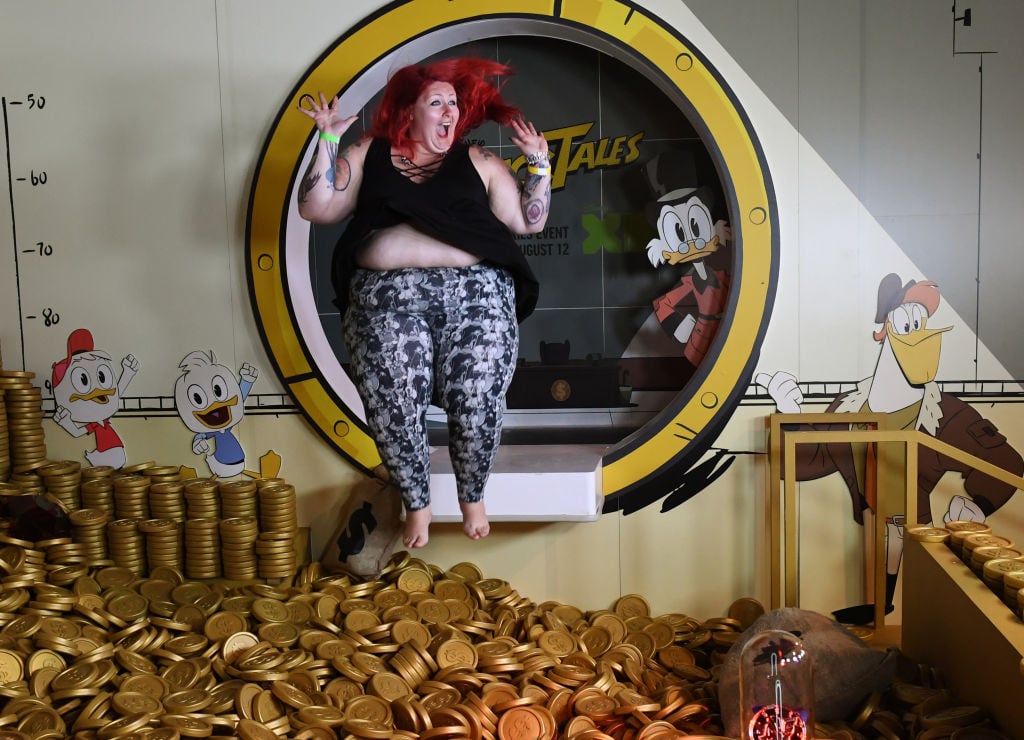 A woman jumps into the money pit at the Duck Tales exhibit
