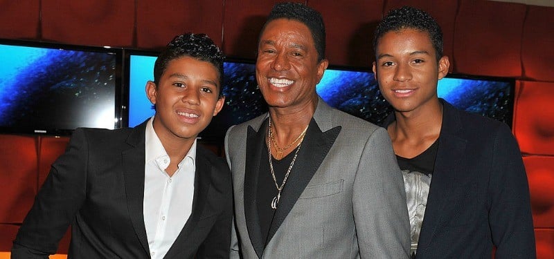 Jermaine, Jafaar, and Jermajesty pose together smiling.
