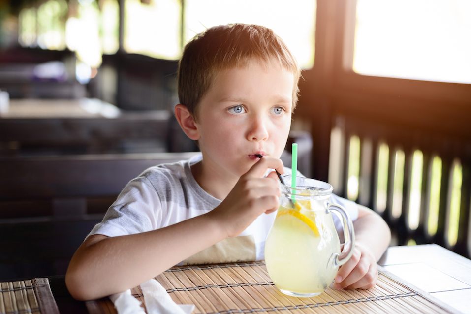 Little child boy enjoying his delicious lemonade