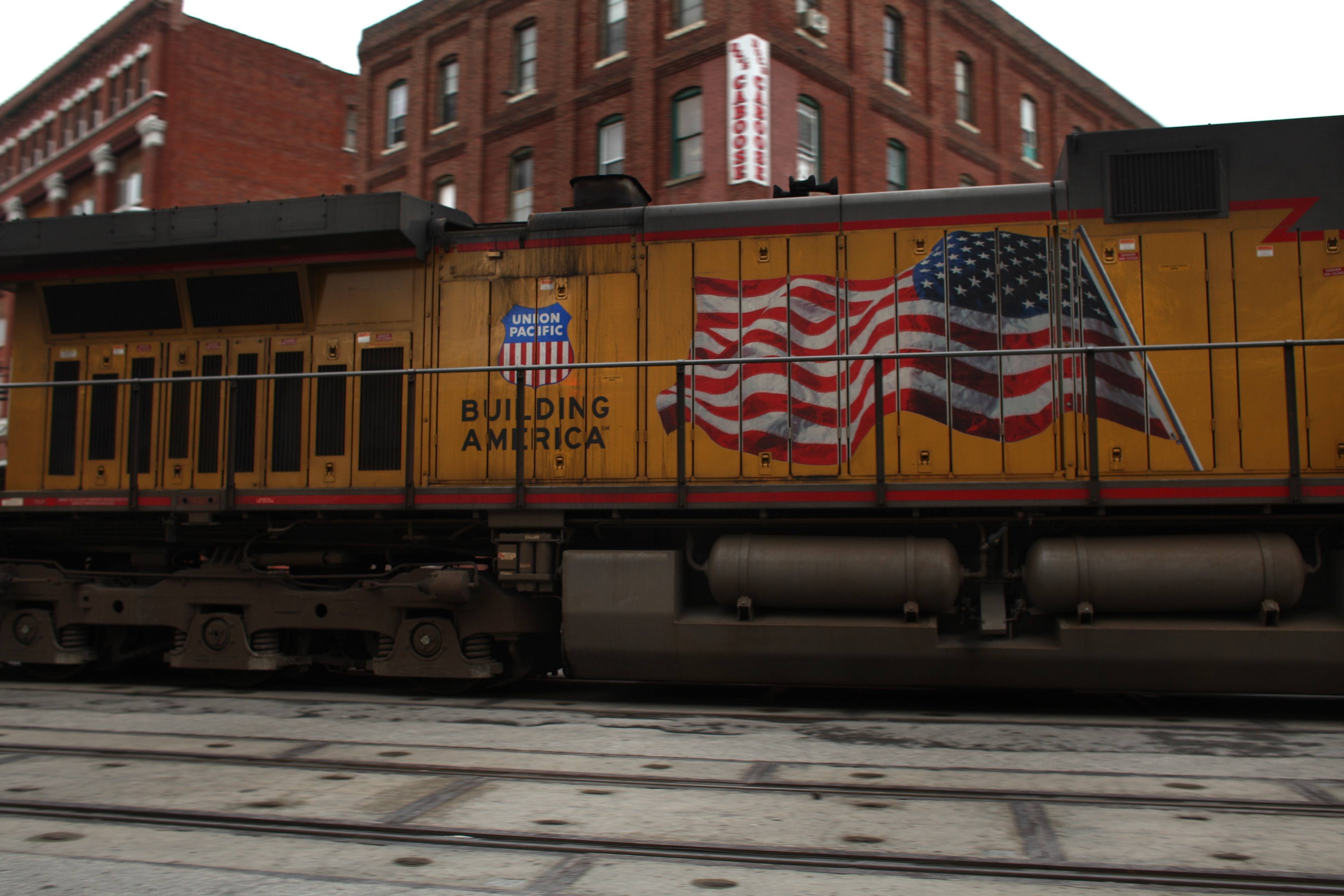 A train passes through an area of old warehouses in Kansas City