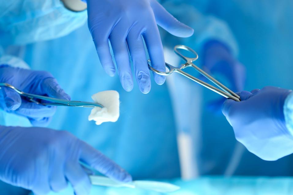 Surgeons hands holding and passing surgical instrument