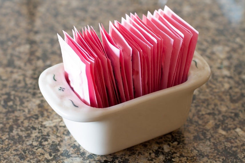 container holding packets of artificial sweetener