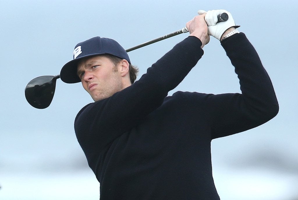 Tom Brady holding a golf club. Tom Brady holding a golf club.