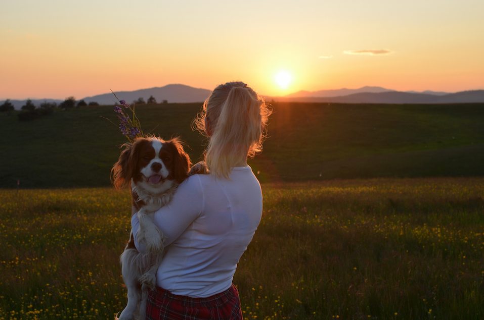 Woman Holding Her Dog in Sunset