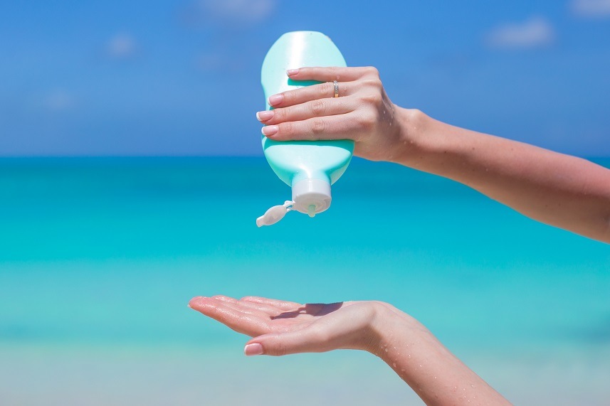 Woman hands putting sunscreen