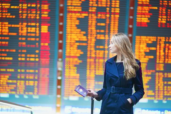 Young woman in international airport near the flight information board