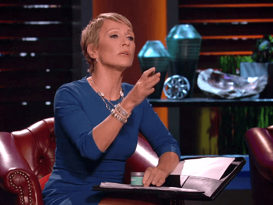 Barbara Corcoran gestures while holding a pen and a notebook on her lap in Shark Tank