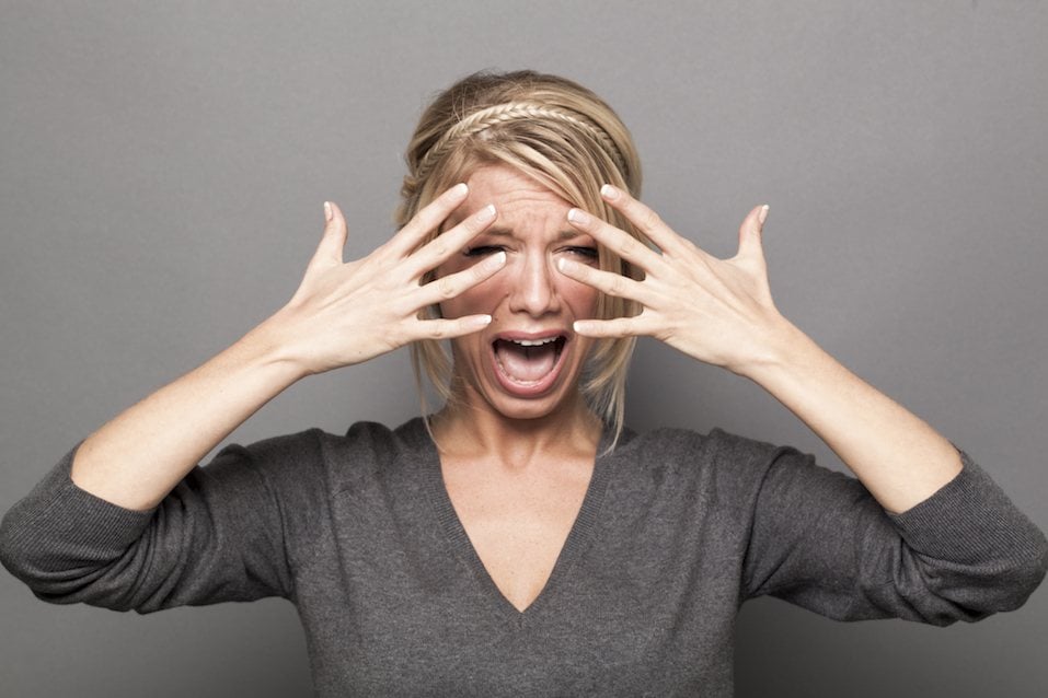 blond girl complaining with tears and hands hiding her face