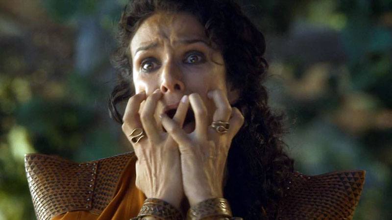 A woman clutching her mouth with her hands A woman clutching her mouth with her hands