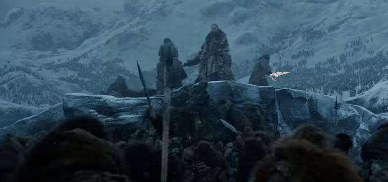 Jon Snow and two other men are on top of a hill in the snow during a battle. One is holding a sword on fire. Jon Snow and two other men are on top of a hill in the snow during a battle. One is holding a sword on fire.