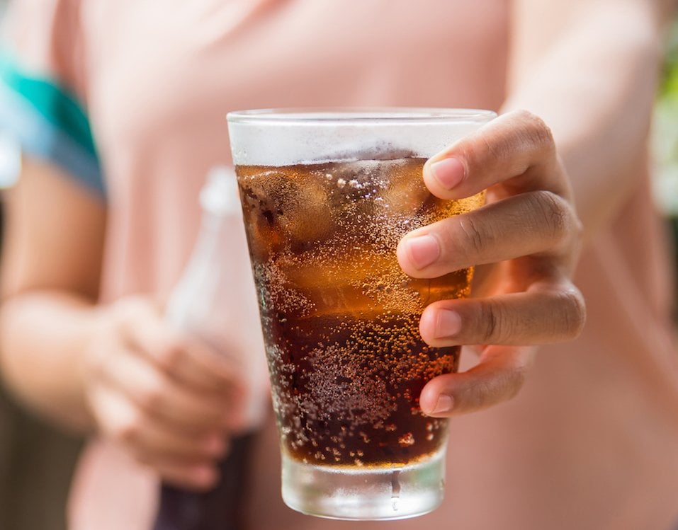 Woman hand giving glass of cola