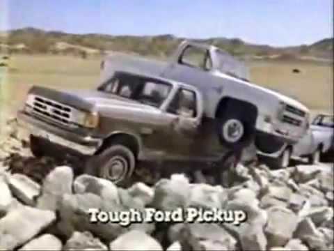 Still from a 1987 ad of a Ford F-250 hauling a Chevy truck and towing a Dodge Ram
