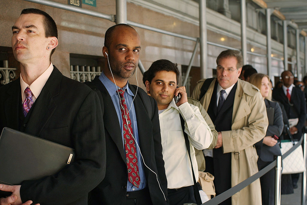People wait in line to speak with job recruiter