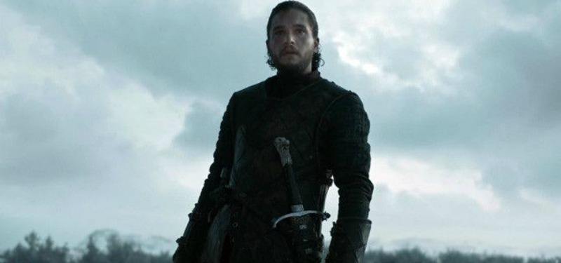 Jon Snow is on a battlefield with his sword at his waist.