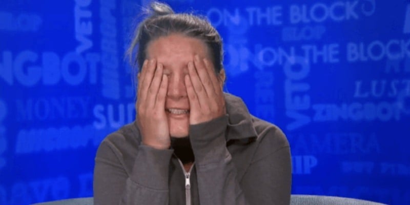 Megan Lowder is covering her face in the diary room.