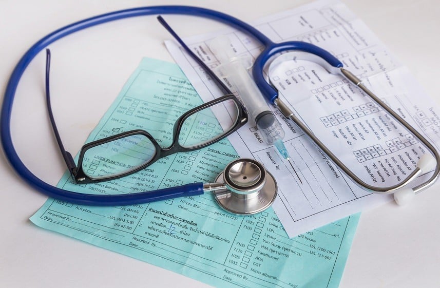 a doctor's glasses, stethoscope, and needle a doctor's glasses, stethoscope, and needle