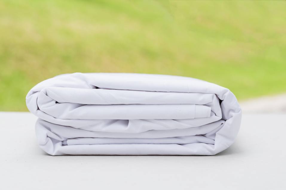 heap of folded white cloth fabrics on wooden table