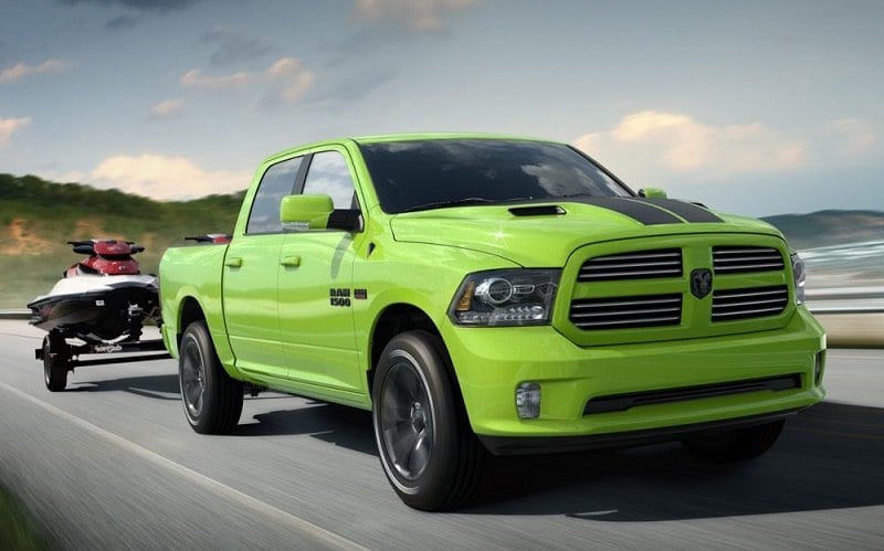 A sublime green Ram 1500 Sport seen towing a jet ski on the highway