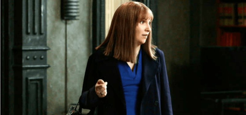 Lena Dunham is in a longer brown wig in an office. Lena Dunham is in a longer brown wig in an office.