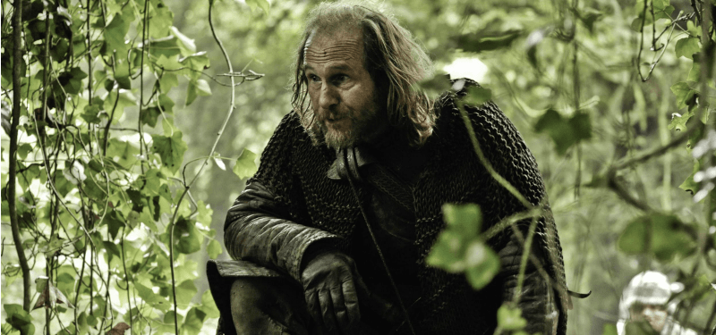 Thoros of Myr is on one knee in the woods. Thoros of Myr is on one knee in the woods.
