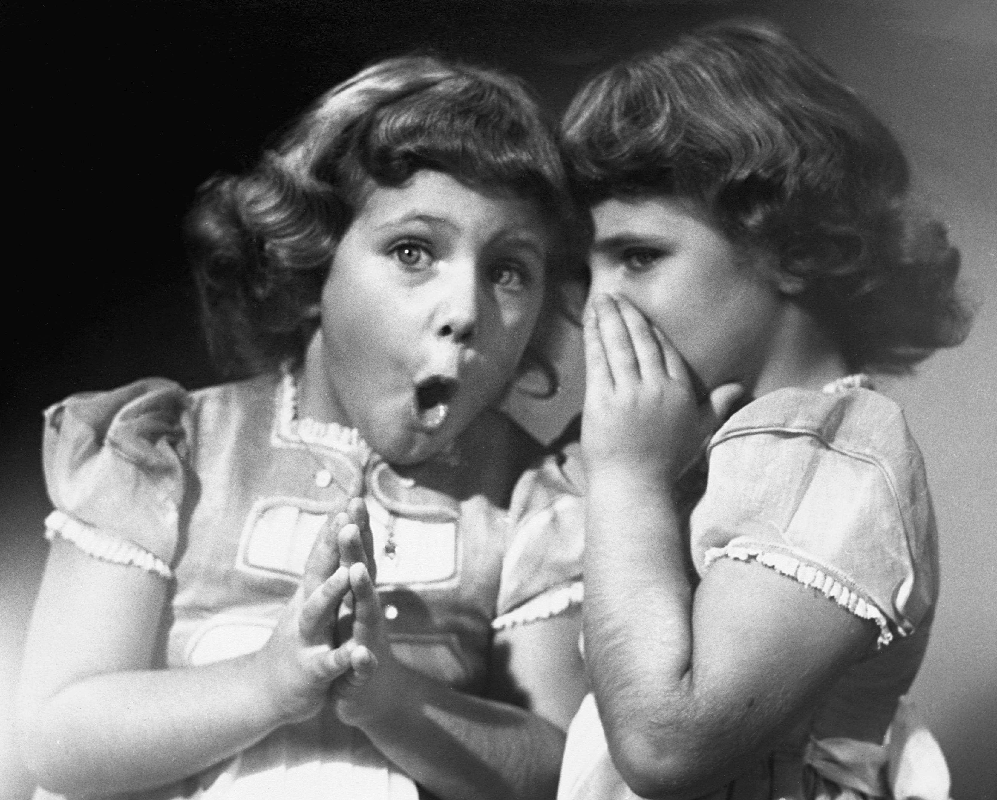 Twin sisters sharing secrets